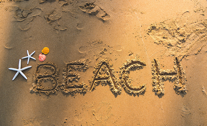 沙滩上写字BEACH海星贝壳和脚印