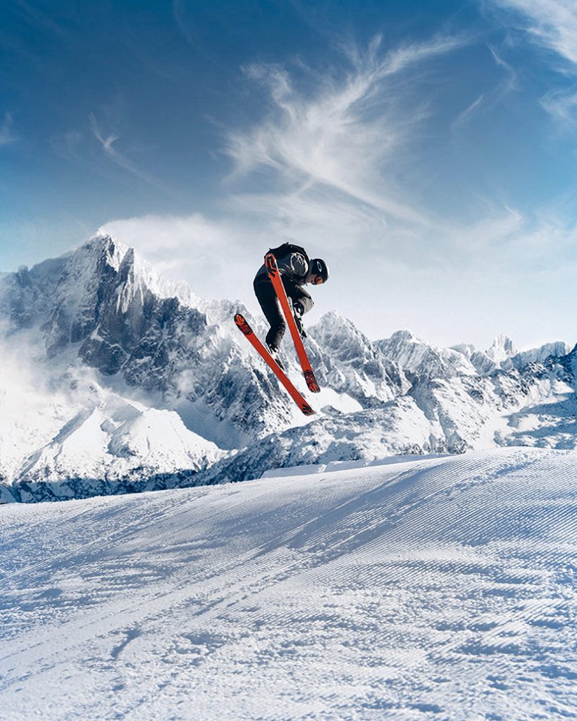 蓝天雪山下的户外滑雪跳跃运动
