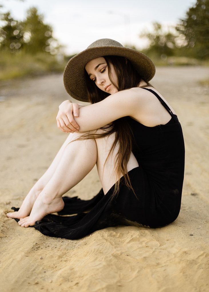 皮肤白皙性感的少女抱膝坐在沙地上