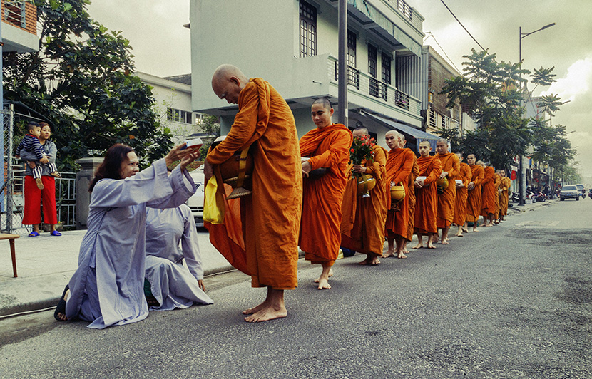 东南亚国家在街上赤足行走的行脚僧和尚接受信徒的布施