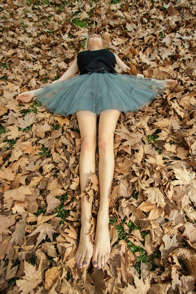 躺在枯叶上的大长腿跳芭蕾的美少女