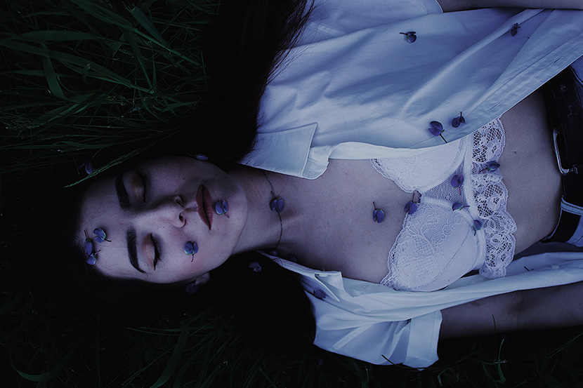 躺在草地上的白色胸衣少女