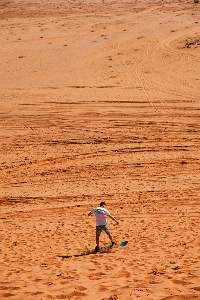 在沙漠中玩滑板的男人