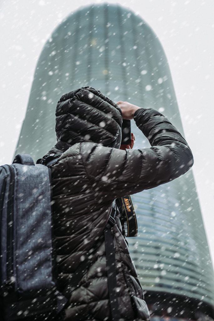 下雪天在城市拍照的男人