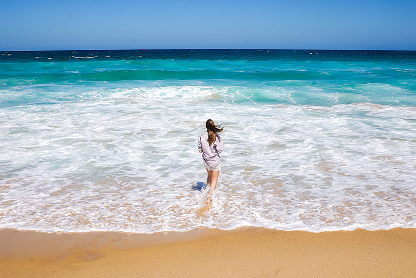 海边沙滩上戏水漫步的女子