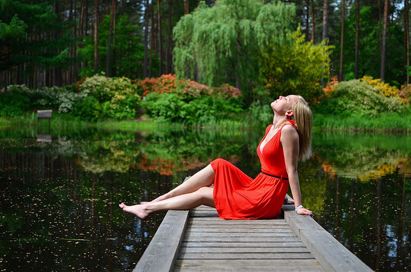 坐在湖堤上的红衣女子