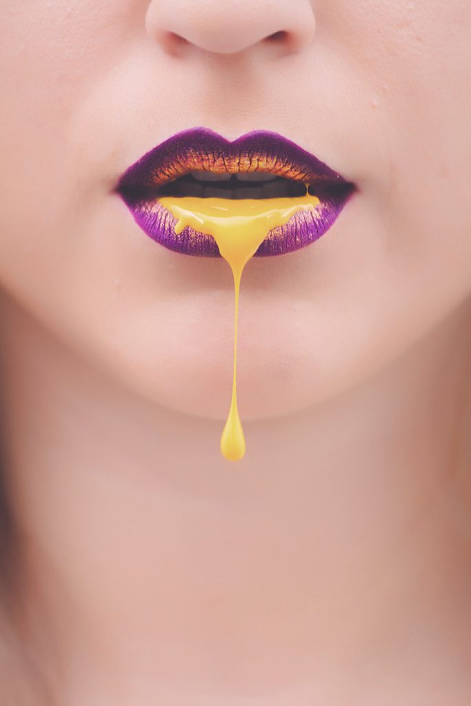 口含黄色液体的紫唇女