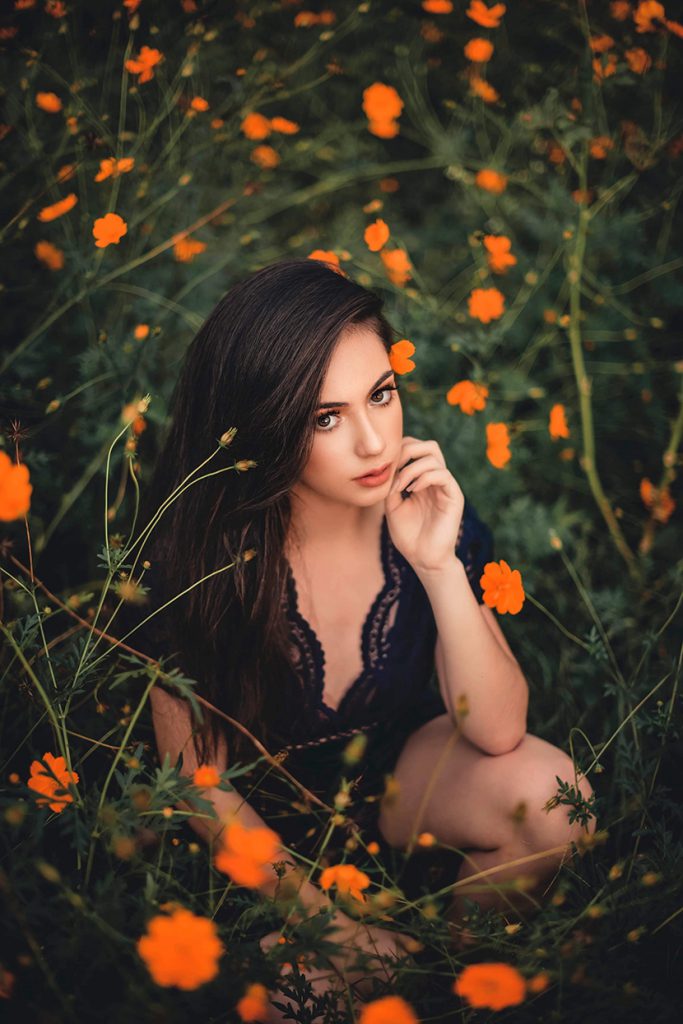 蹲在花草丛中的漂亮少女