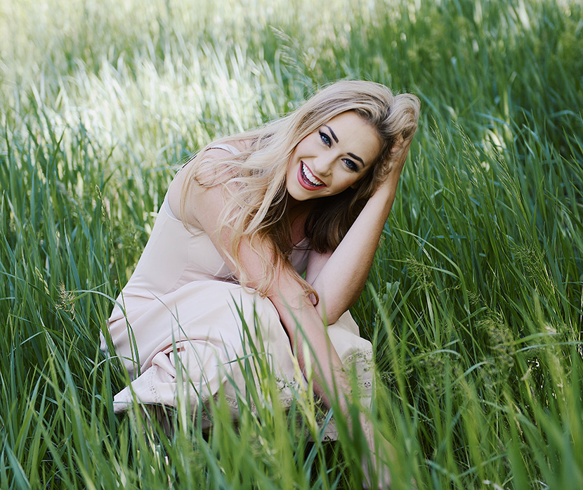 蹲在草丛中大笑的美女