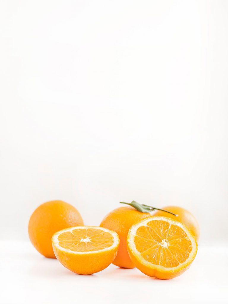 白色背景板前的桔子橙子