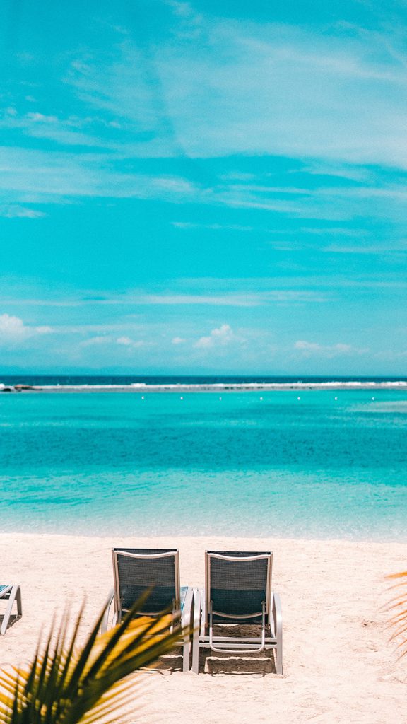 蓝天下的沙滩和躺椅