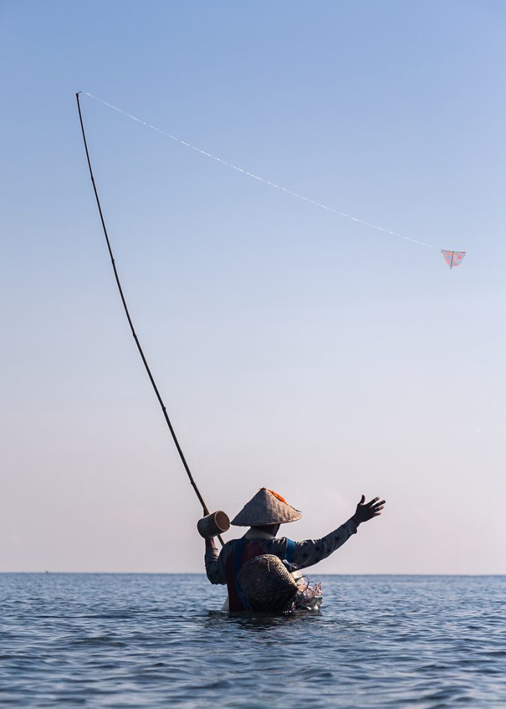 在浅海中放风筝还是捕鱼的人