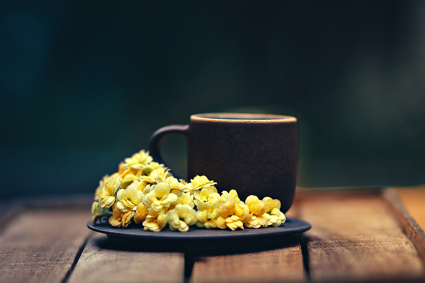咖啡杯前的小黄花