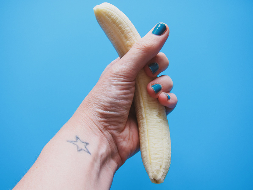 女人手中握着的一根细长的香蕉