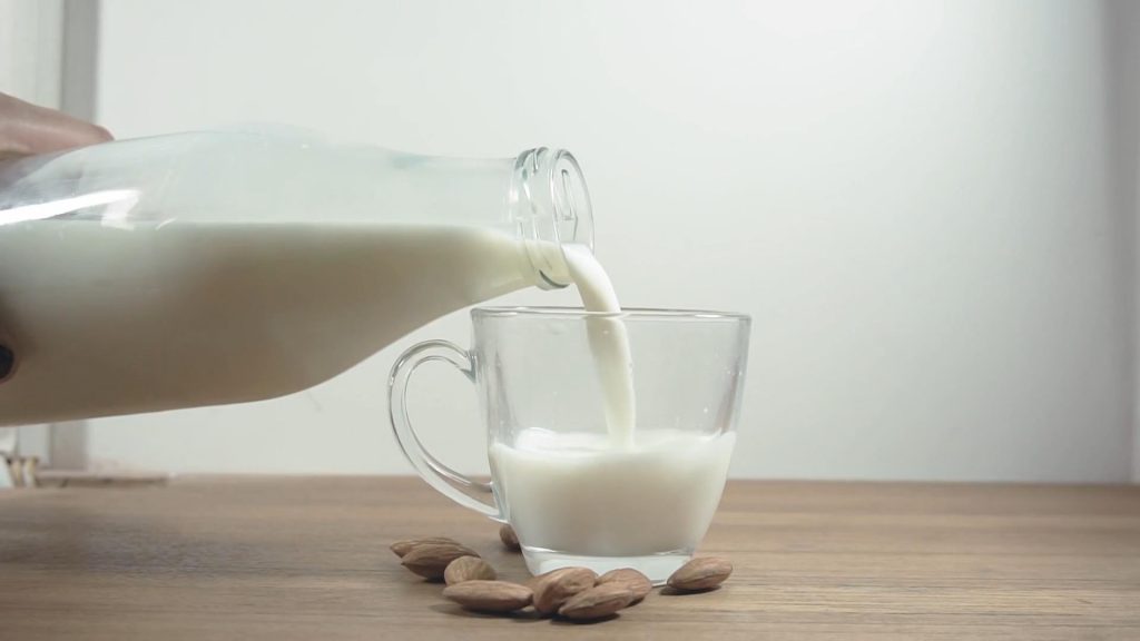 往玻璃杯中倒牛奶升格慢动作短视频素材