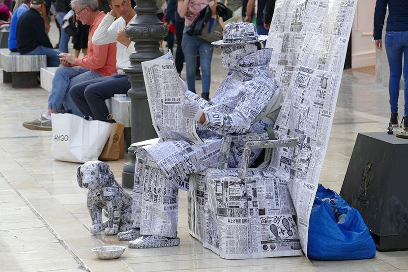 街头行为艺术，用报纸包裹的男人和小狗