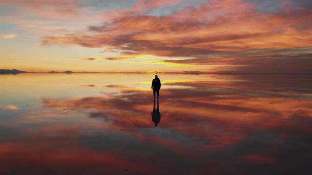 站在海边晚霞中天空之镜的男人航拍短视频素材【4K】
