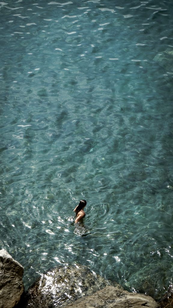 海岸礁石边游泳的女人