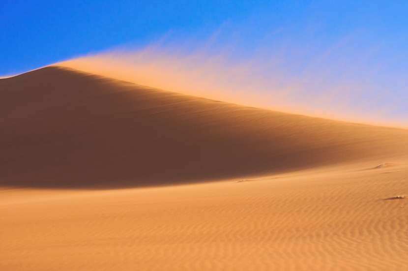 蓝天下的沙漠沙丘起风了