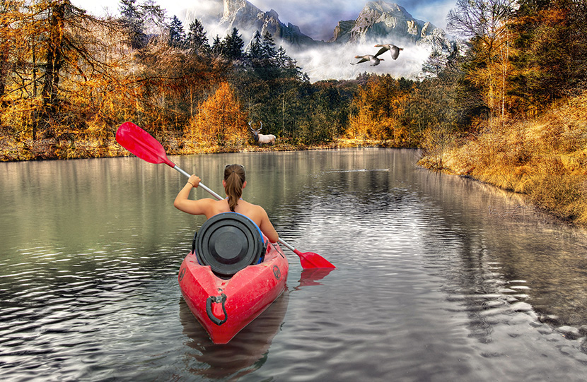 在深山湖泊中玩皮划艇的女人