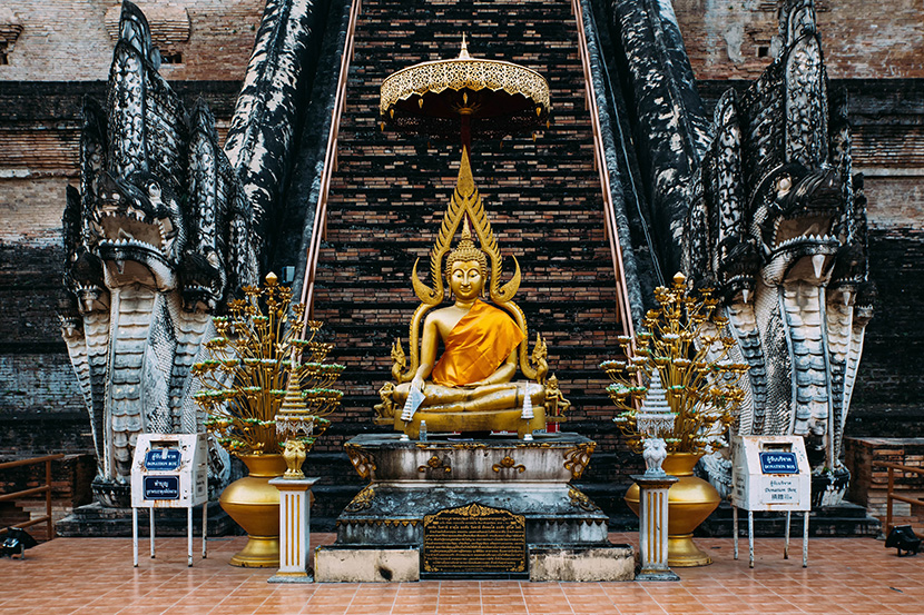 泰国古寺庙前的金佛雕像