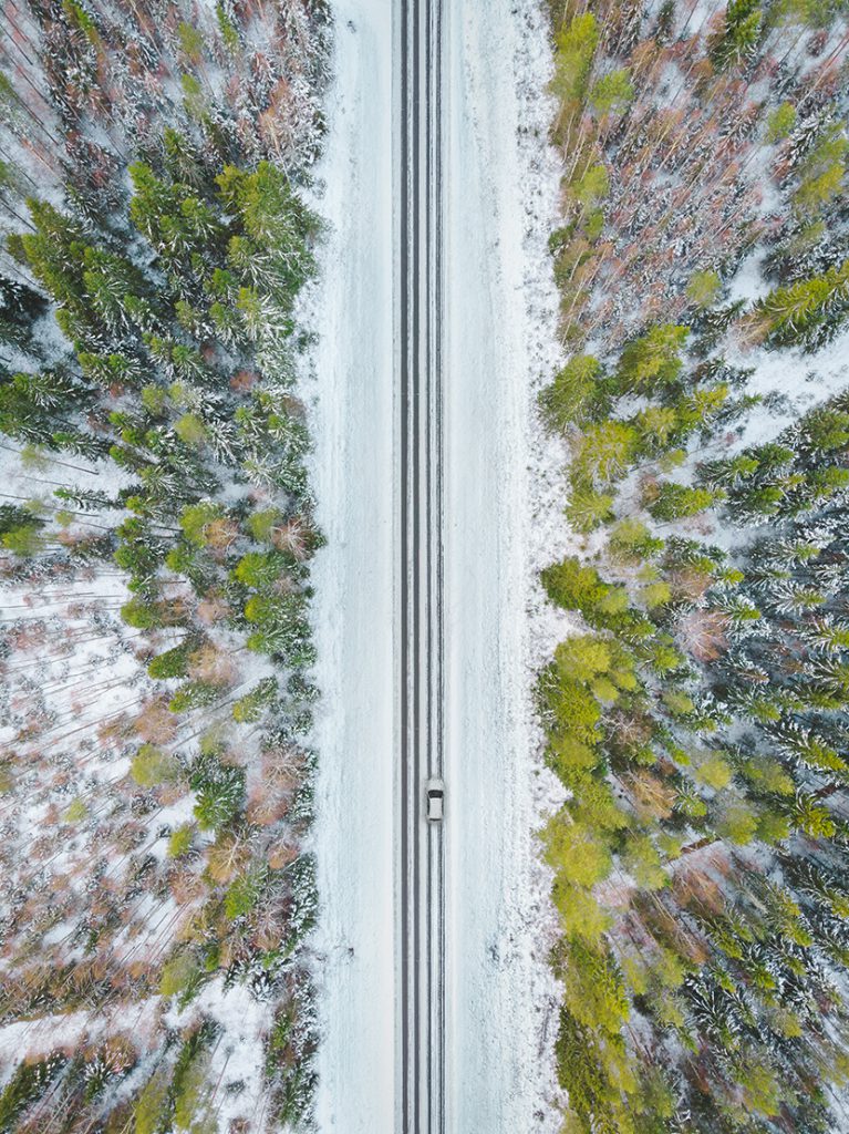 雪地森林中一辆行驶的小汽车