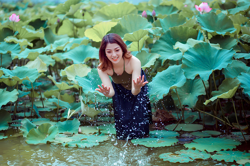 在荷塘中戏水的性感越南妇人