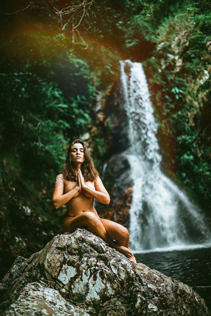 在深山老林的小溪瀑布边打坐冥想的裸女