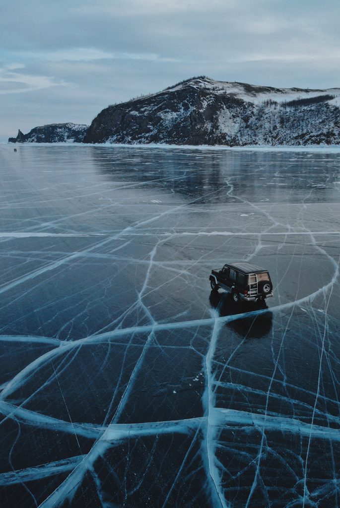 在结冰的湖面上行驶的SUV汽车