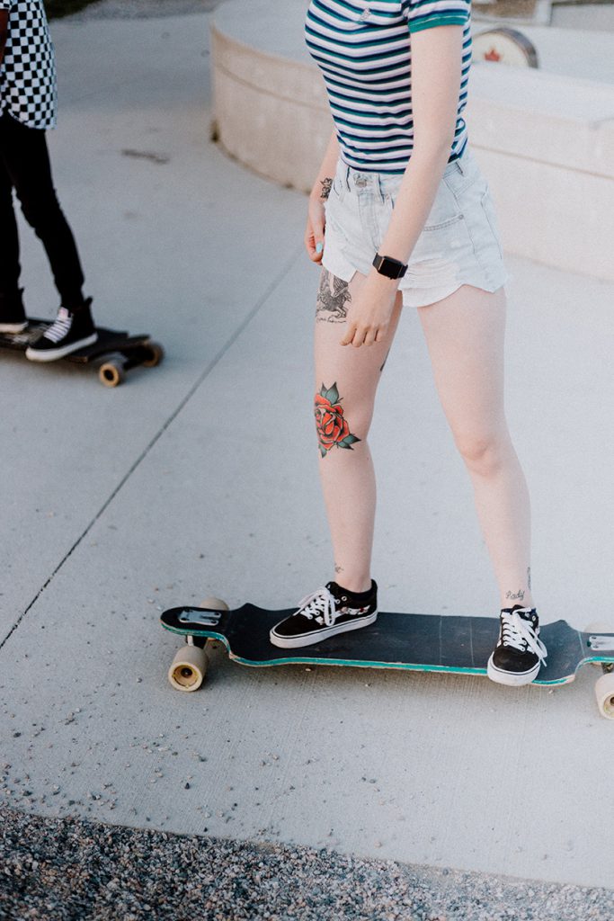 在街边玩滑板的少女