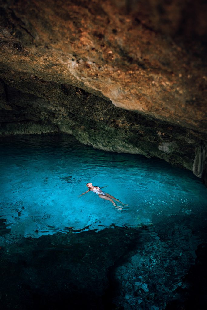 在洞穴湖泊中游泳的美女