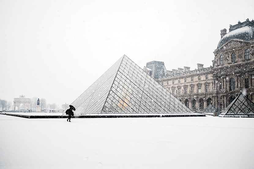 雪中的卢浮宫前的玻璃金字塔