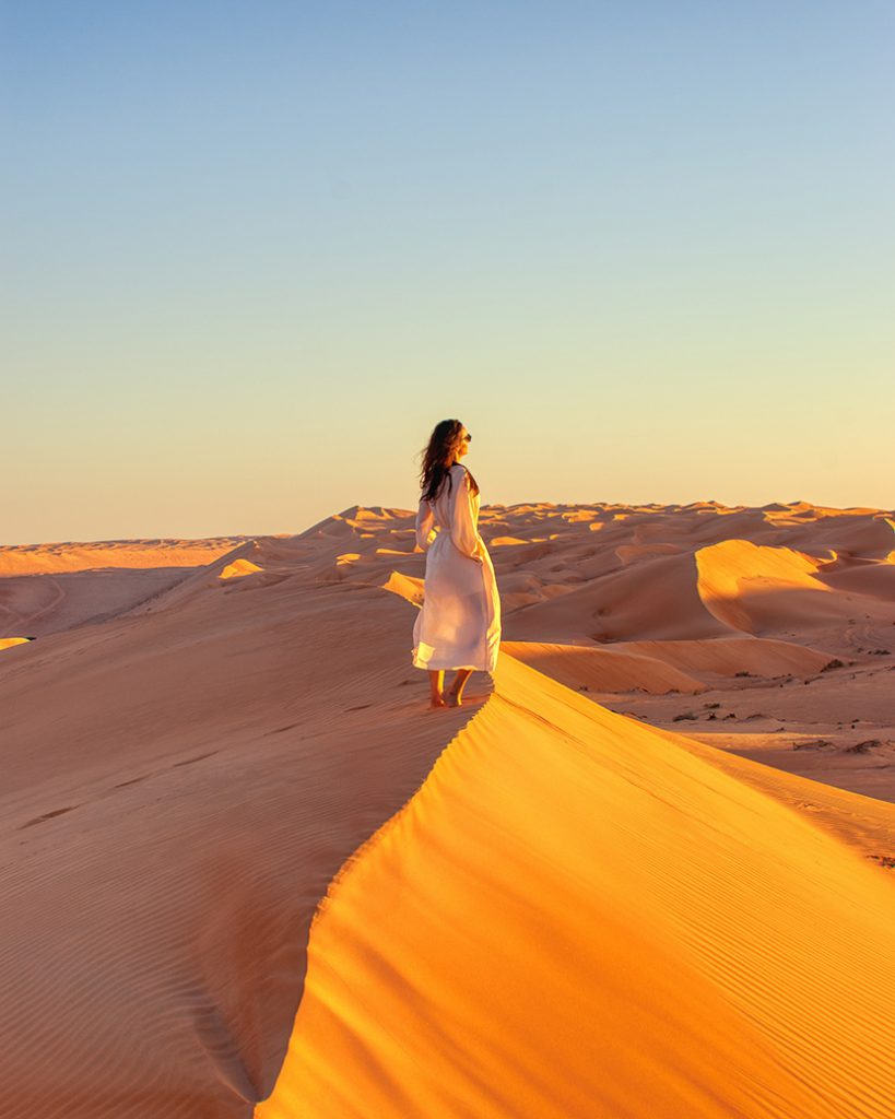 站在沙丘上看太阳的女人