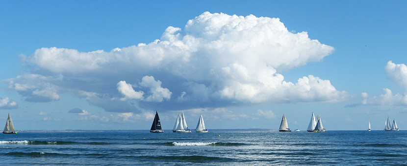蓝天白云下海边的几艘帆船