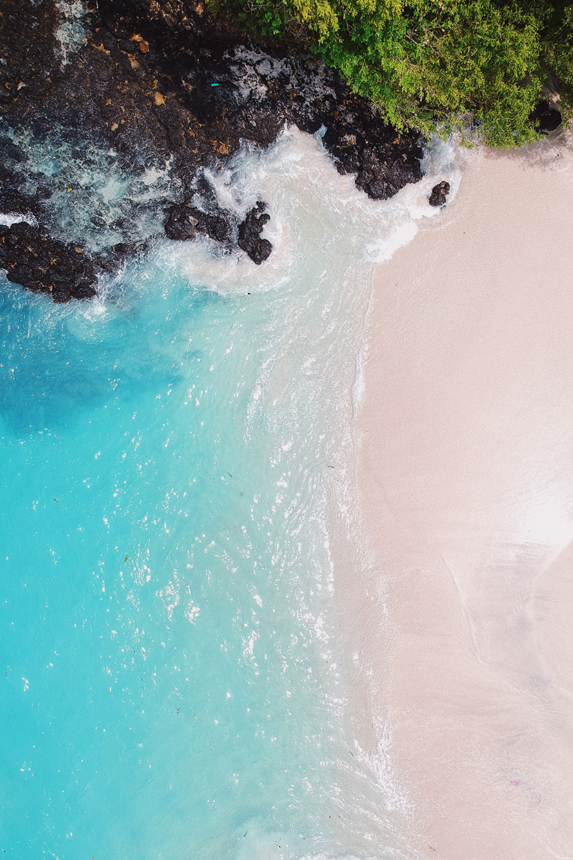 粉色沙滩黑色礁石碧蓝海水