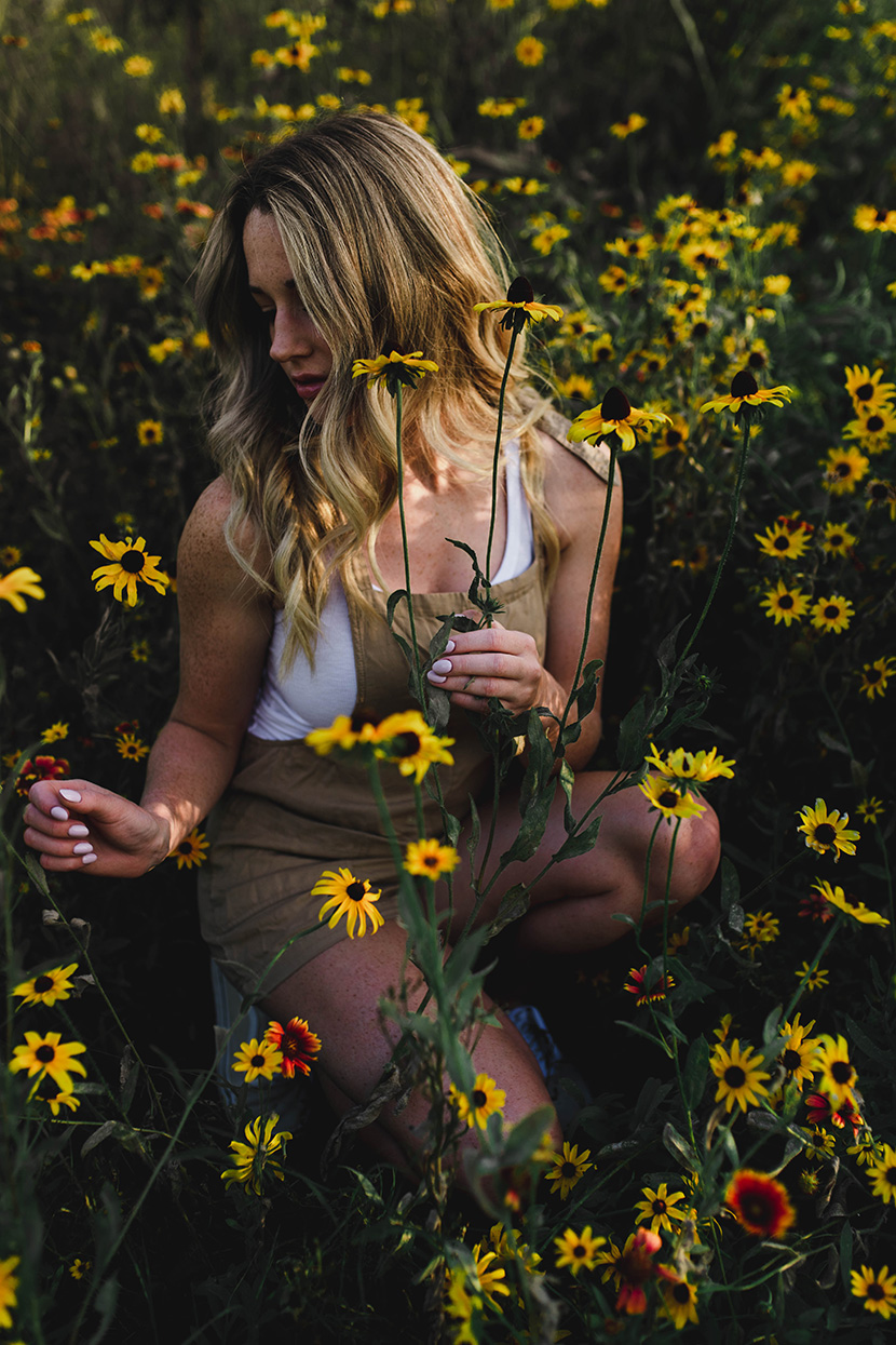 蹲坐在花草丛中的金发雀斑少女