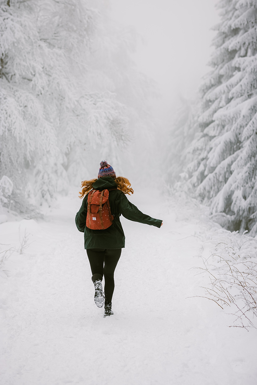 在雪山森林中奔跑的女人