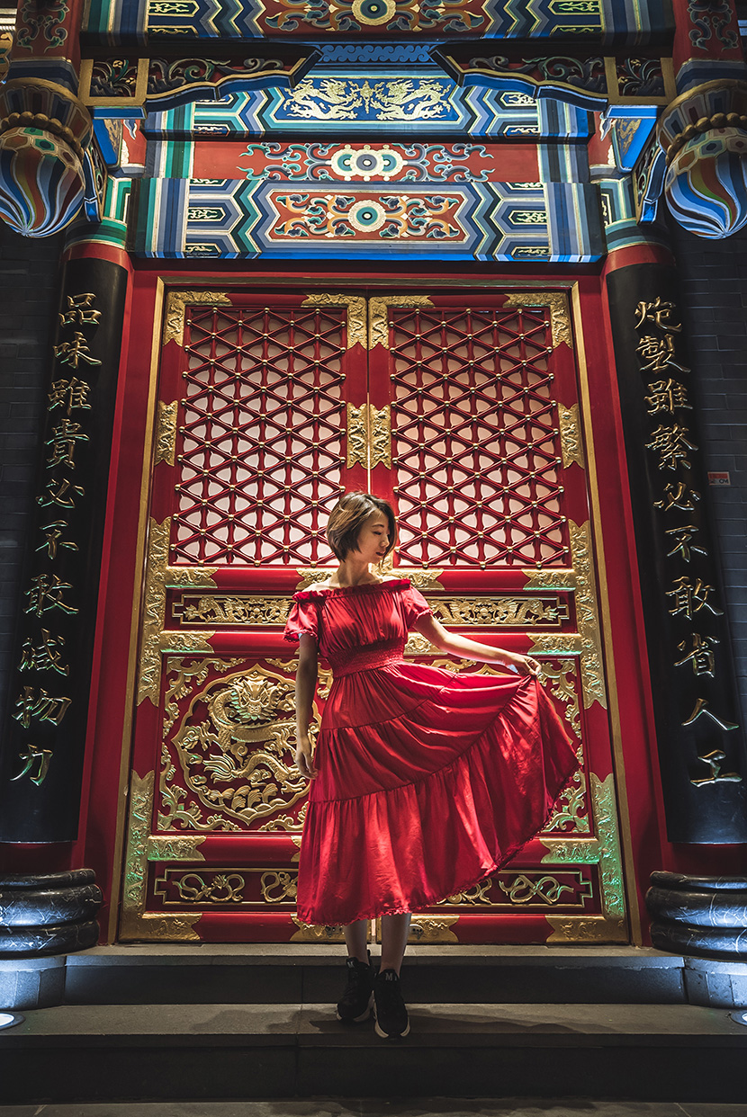 古典中式豪华大门前的红衣少女