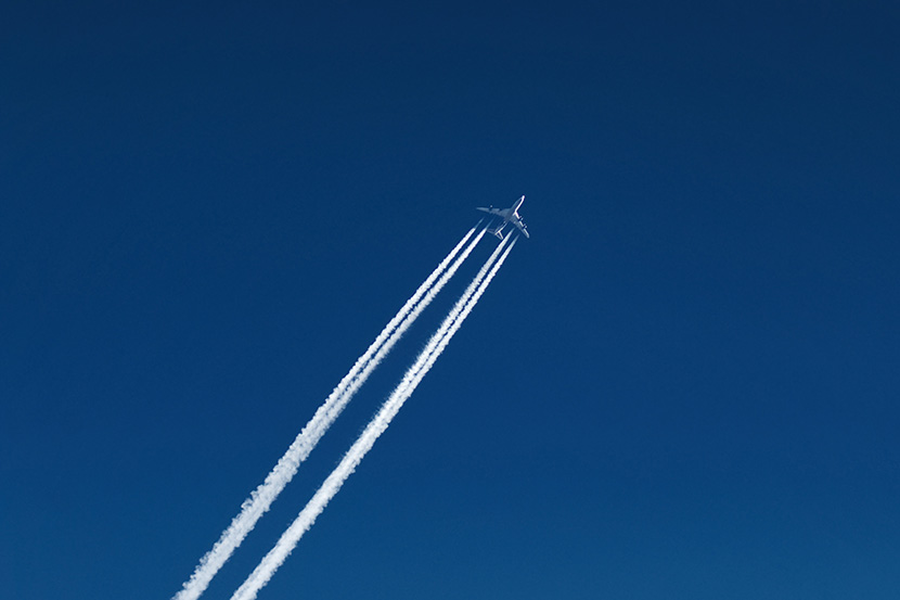 蓝天下的航班客运飞机。飞机飞过留下一条白线叫尾迹云,即机尾云,俗称飞机拉烟,