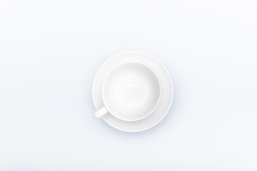 白桌子上的一个白瓷咖啡杯