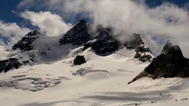 高原雪山山峰之间的云雾变化延时短视频素材