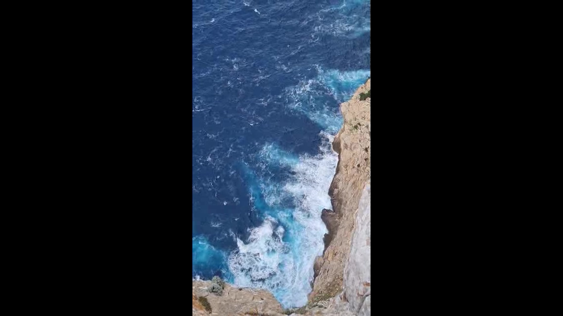悬崖峭壁上俯瞰大海拍浪短视频素材